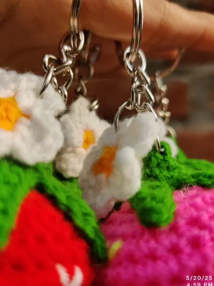 Sweet strawberry and daisy keychains. These come in red, pink, and purple, each with a little white flower.