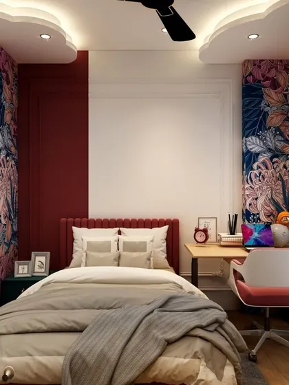 A bedroom designed with bold colors and patterns. The deep red accent wall and floral wallpaper panels create a dramatic and personalized space, complemented by a compact study nook.