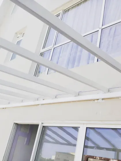 The simple, strong lines of the white pergola frame against the house. This style is incredibly versatile and works well with modern architecture.