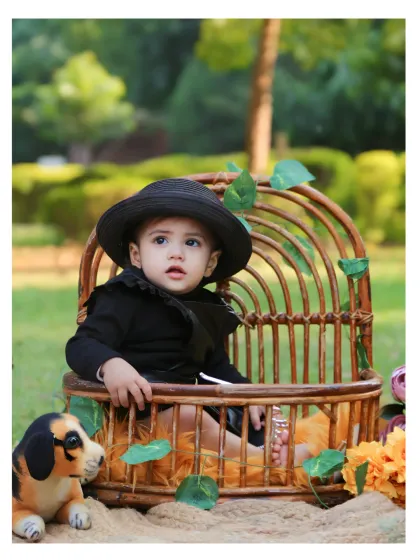 A close-up of the well-dressed birthday boy in his rustic outdoor setup.