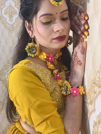 An artistic pose showing the detailed henna on the hands and the coordinated yellow nails, completing the Haldi look.