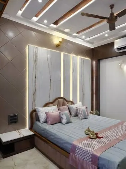 This bedroom features a beautiful backlit headboard with a marble-like finish. The soft color palette of blue, pink, and beige creates a calming and sophisticated space.