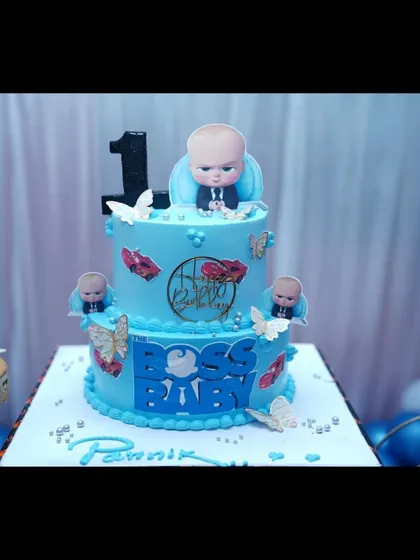 A close-up of a Boss Baby themed birthday cake, showing the detailed character work.