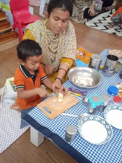 A child learns to chop soft fruits with a parent's guidance. This is a safe and effective way to introduce practical kitchen skills and build a child's confidence.