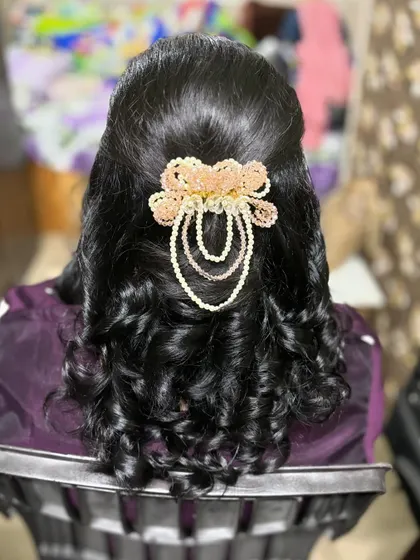 A simple yet elegant hairstyle with soft curls and a beautiful pearl accessory. This look was created based on the client's specific request for her event.