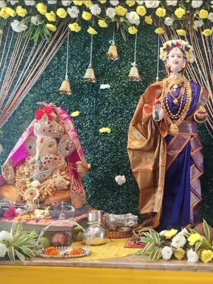 I also create special setups for Gauri Ganpati. This decor features a green backdrop with yellow and white floral arrangements, hanging bells, and pampas grass accents, creating a harmonious and traditional space for both deities.