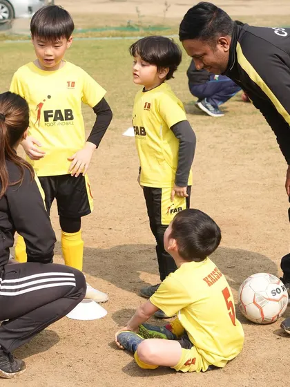 A typical huddle at our academy. Here, coaches and young players come together to discuss tactics and learn from each other, fostering a collaborative and supportive environment.