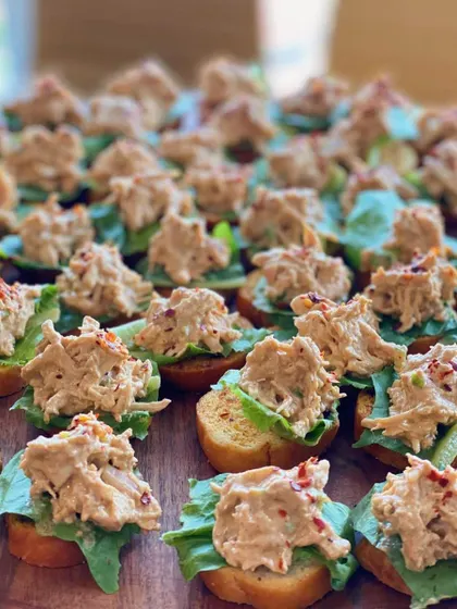 A close-up of our delicious chicken salad crostini. The creamy, seasoned chicken on a crisp slice of bread is a simple yet satisfying appetizer for any occasion.