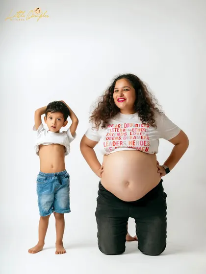 Like mother, like son. This cute pose showing off their bellies is a fun and memorable moment from a family maternity session.
