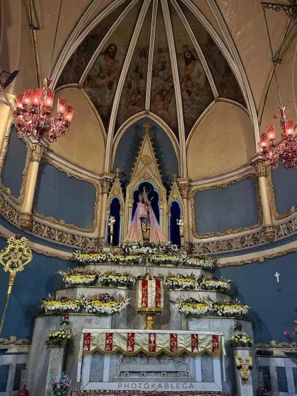 The beautifully decorated altar inside Mount Mary Basilica during Christmas, showcasing intricate floral arrangements and warm lighting under the painted dome.