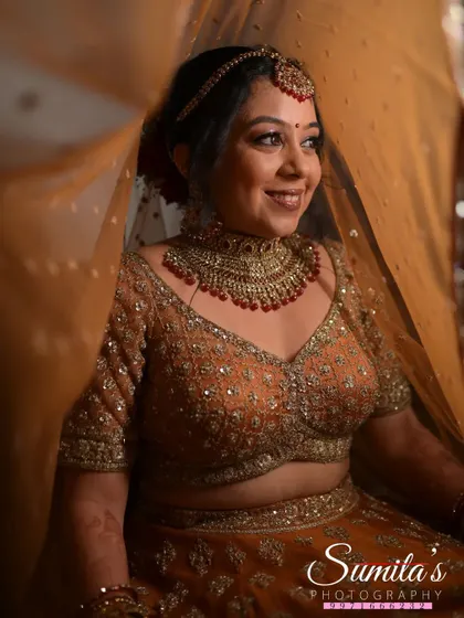 A soft and gentle bridal portrait. The bride's serene smile is captured through her veil, adding a layer of traditional elegance to the shot.