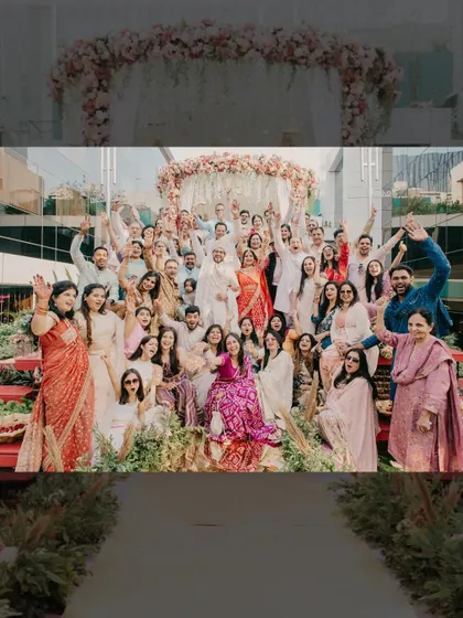 A joyous group photograph with all the family and friends, capturing the collective happiness of the wedding day.