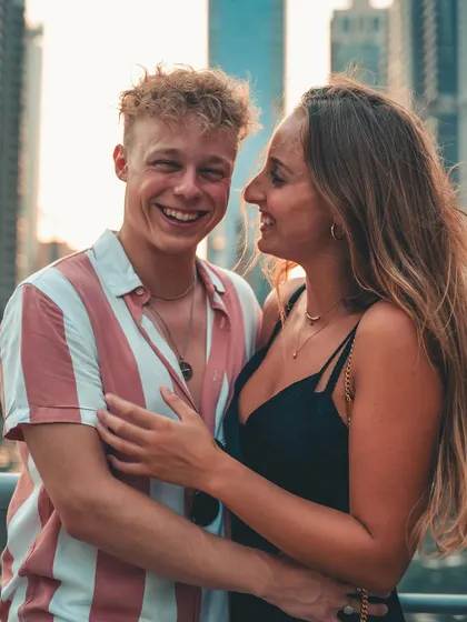 A duplicate of image 5, a joyful, candid moment between a couple against a modern city skyline.