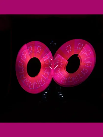 Pixel-perfect spins light up the night. This image shows our poi artist creating mesmerizing pink circular patterns.
