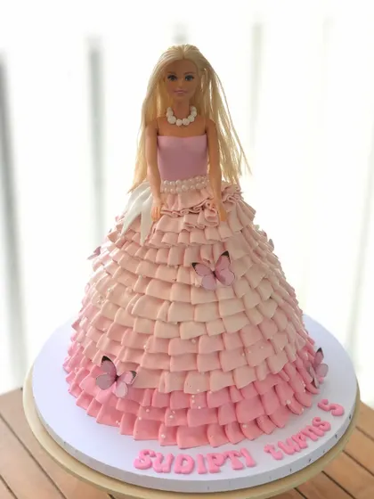 A classic Barbie doll cake, where the cake itself becomes her beautiful, flowing gown. This one features an ombre pink ruffle design.