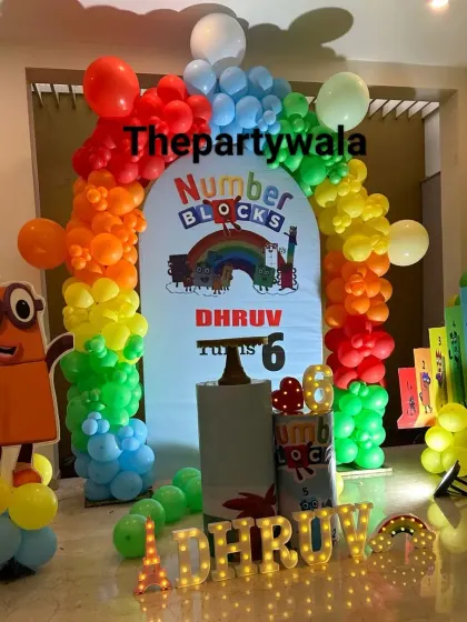 An educational and colorful Numberblocks theme for a 6th birthday. This setup features character cutouts and a rainbow balloon arch, making learning fun.