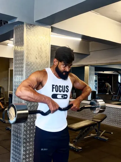 Focus mode on. An EZ bar curl, concentrating on form to maximize bicep engagement.