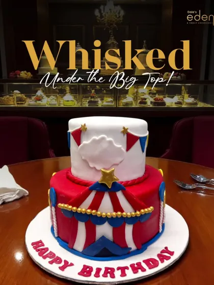 Whisked under the big top! This vibrant, two-tier circus-themed cake is decorated with red and white stripes, stars, and bunting, bringing all the fun of the circus to a birthday celebration.