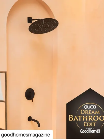 The shower area from my Dream Bathroom Edit, featuring a black rain showerhead set against a textured, peach-toned wall with an arched niche.
