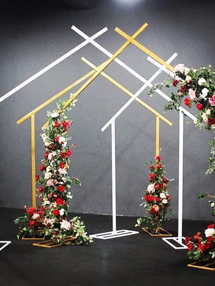 A modern and minimalist wedding arch. The clean geometric lines, accented with beautiful floral arrangements, create a chic and stylish backdrop for a ceremony or photo booth.