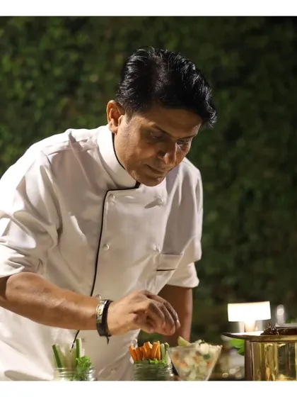 One of our senior chefs meticulously adding the final touches to a dish, reflecting the experience and artistry that anchors our culinary team.