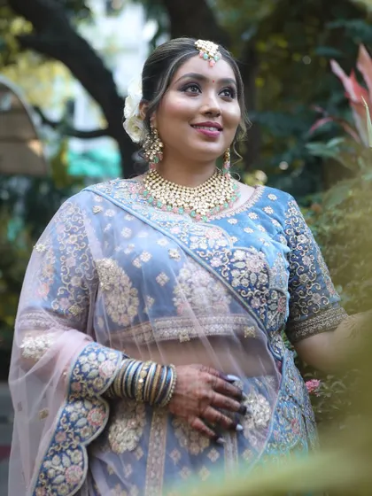 A full-length shot that captures the entire look, from the elegant hairstyle to the detailed embroidery on the lehenga.