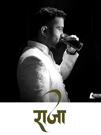 A portrait of the groom, Bhuvnesh, titled 'Raja' (King), looking regal in his white sherwani.