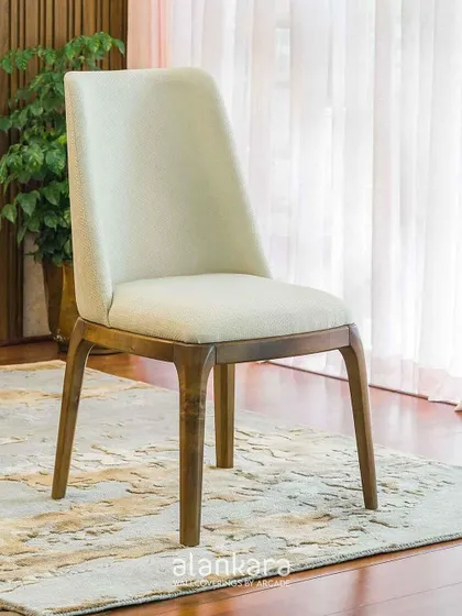 The White Arber dining chair, shown here as a standalone piece. Its high back and plush seat, upholstered in a textured white fabric, provide exceptional comfort and support.