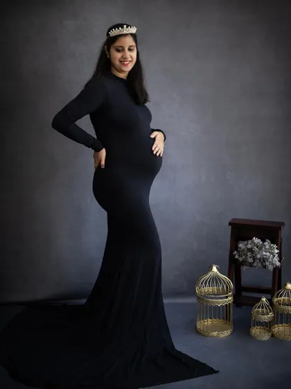 A smiling mom-to-be, looking like a queen in her black gown and tiara. We love to make our clients feel special and celebrated during their session.