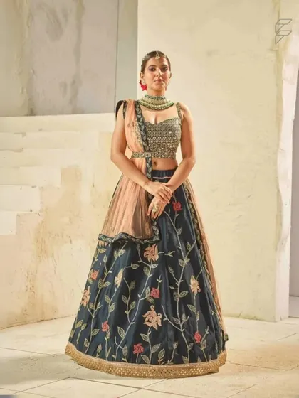 This dark blue floral embroidered lehenga is a sophisticated and elegant choice. It is perfect for an evening reception or cocktail party.