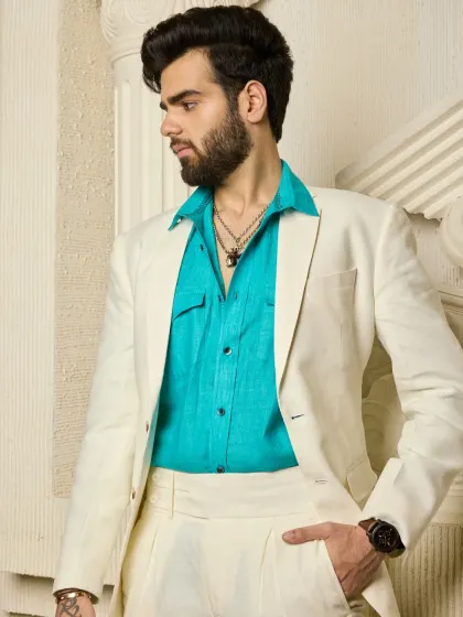 I enjoy creating looks that blend classic silhouettes with refreshing colors. This crisp cream linen suit is paired with a vibrant turquoise shirt, offering a sophisticated and breathable ensemble perfect for summer events or a stylish daytime engagement.