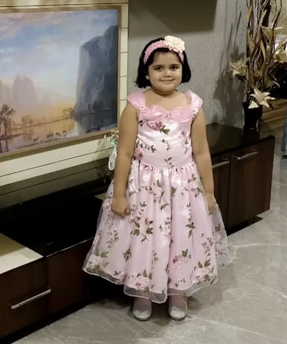 A happy customer ready for her birthday party in a beautiful floor-length pink floral gown. This dress is all about making her feel special on her big day.