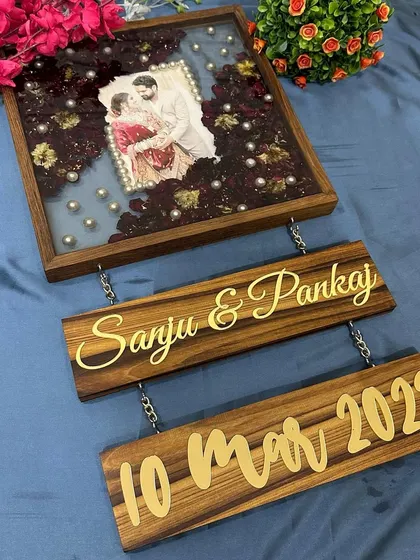 This 12-inch teakwood frame includes two hanging wooden plaques below it, personalized with the couple's names and wedding date in gold.
