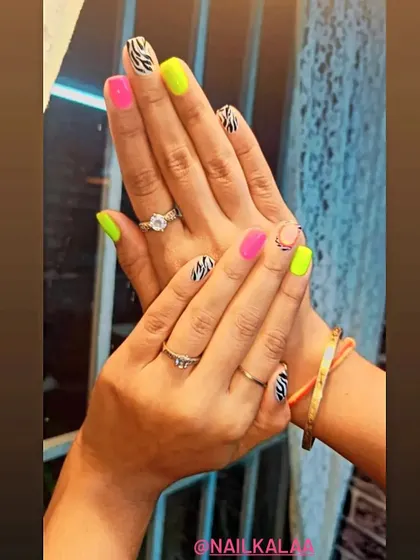 A bold and fun mix-and-match set, combining neon pink and yellow nails with black and white zebra print accent nails.