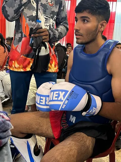 A young fighter sits focused and ready, moments before his match. We train our students to be calm and composed, even in the high-pressure environment of a championship.