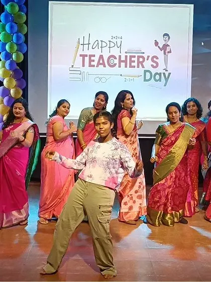 A student leads the teachers in a fun dance, creating a lively and interactive atmosphere.