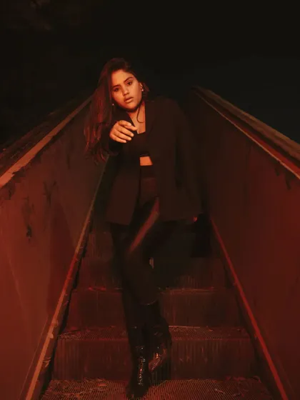 A low-light portrait on a derelict escalator, lit with a dramatic red gel. This technique creates a gritty, cinematic, and slightly futuristic look, perfect for an edgy fashion shoot.