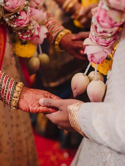 A close-up of the couple holding hands, a simple yet powerful symbol of their union and commitment.