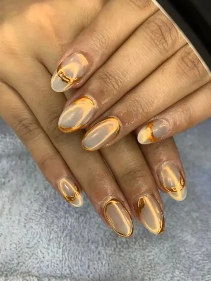 A sophisticated design combining a matte nude base with raised, liquid-gold chrome accents. This look is perfect for someone who wants an artistic and elegant manicure.