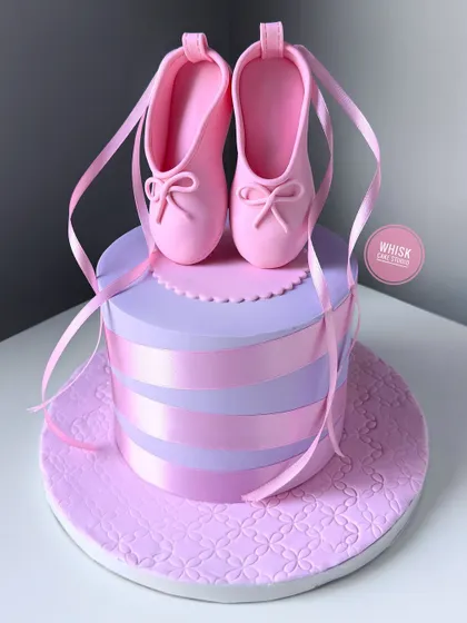 For your little ballerina. A non-fondant cake with beautiful, handcrafted fondant ballet shoes on top, complete with delicate ribbons.
