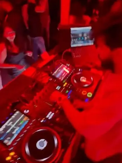 A top-down view of my DJ setup under the red lights of the club. You can see the complexity of the gear I use to create my sound.