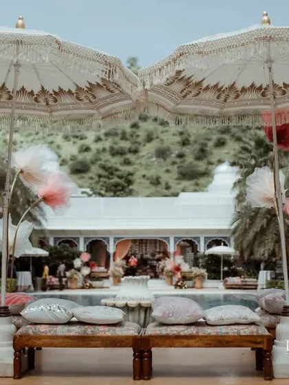 Ornate umbrellas and poolside seating create a lavish and relaxing atmosphere for this Haldi celebration at the Leela Palace, Jaipur.