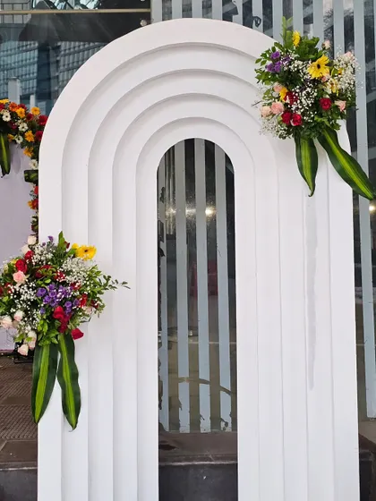 In addition to floral arches, I also create modern decor elements like this white tiered archway. Adorned with simple, elegant floral bouquets, it offers a contemporary alternative for event entrances or photo points.