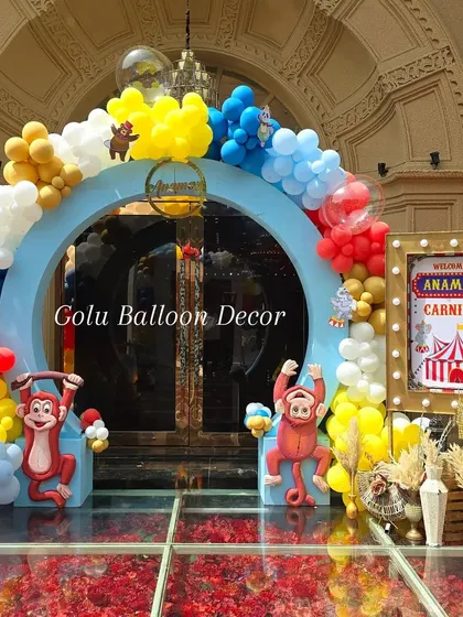 A close-up of the carnival entrance arch, detailed with monkey cutouts and a custom light-up sign for "Anamay's Carnival".