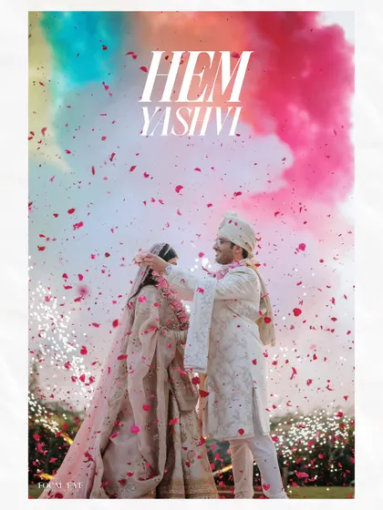A vibrant and modern wedding moment, with the couple framed by a burst of colorful smoke and a shower of petals.
