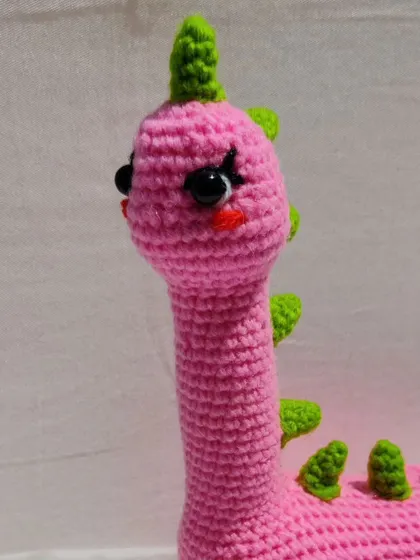 A close-up on Mrs. Dino's sweet, hand-stitched face.