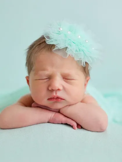 A simple and sweet portrait of a newborn with a slight frown, showing the range of expressions we capture.