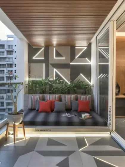 A modern balcony designed for lounging. This space features a large, built-in daybed with plush cushions. The geometric patterns on the wall and floor are highlighted with integrated LED strip lighting for a futuristic look.
