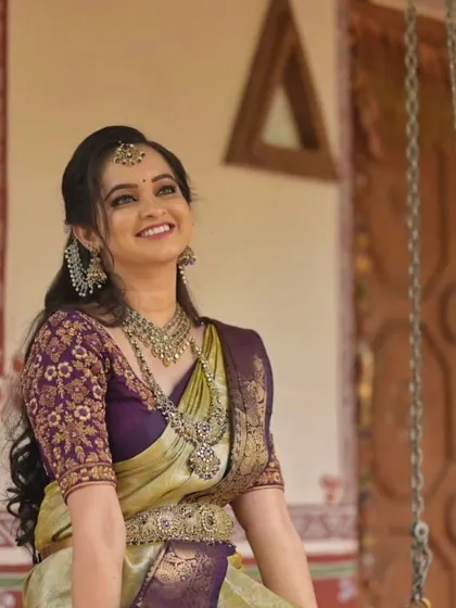 A model showcasing a rich purple and gold silk saree. The oxidized silver jewelry adds a contemporary twist to this traditional outfit, making it suitable for both weddings and festive events.