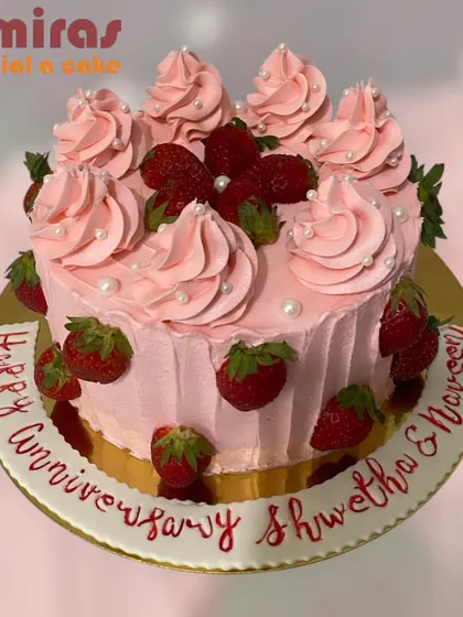 A fresh and fruity strawberry cake. The pink frosting is swirled beautifully and decorated with fresh strawberries, making it a perfect and delicious anniversary treat.